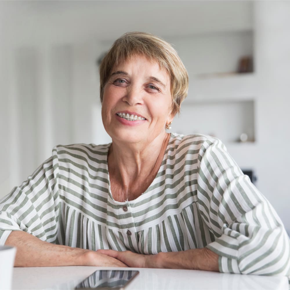 An older woman is smiling, showing off her ceramic braces.