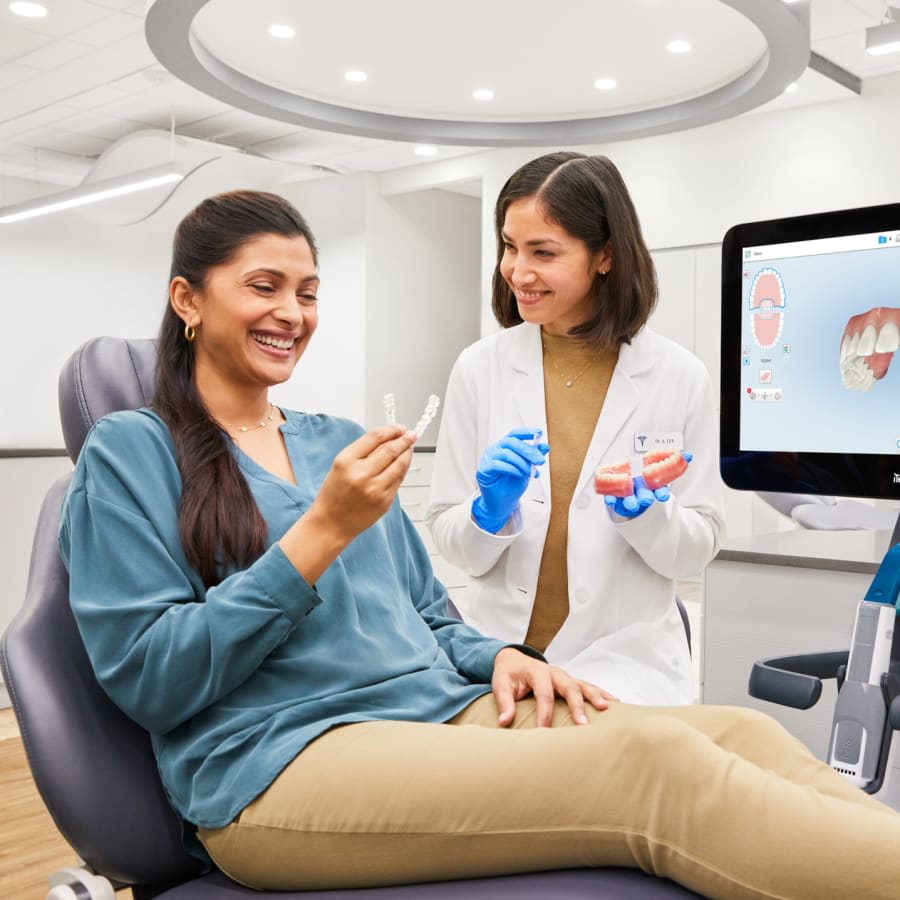 An orthodontist hands a patient an Invisalign tray.