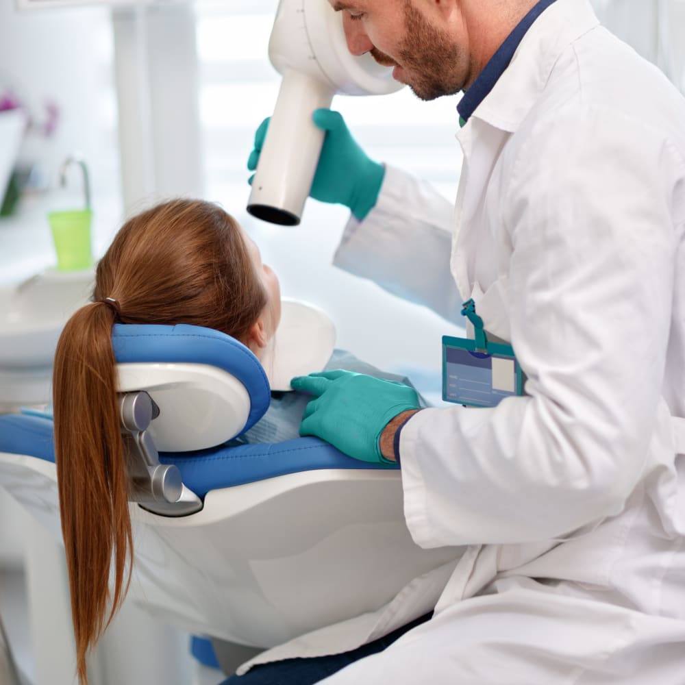 A dentist performs a dental x-ray on a patient.