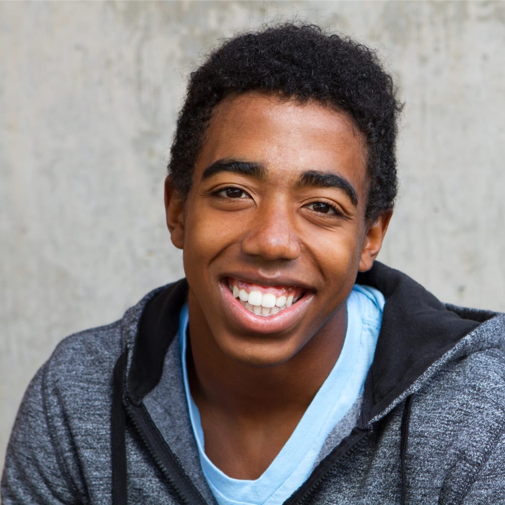A teenage boy is smiling.