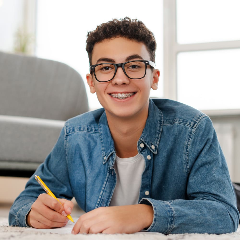 A teenage boy is smiling, showing off braces.